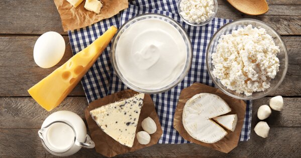 Gedeckter Tisch mit Käsesorten, Milch und ein Ei