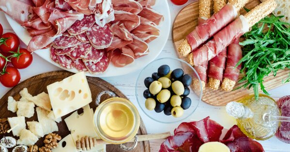Wurst- und Käseplatte mit einer Schale Oliven
