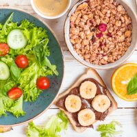 Salat, Tomaten, Gurken, Banane, Toast mit Schokoaufstrich und Banane. Spiegelei, Cerealien, Pfannkuchen und Orangen